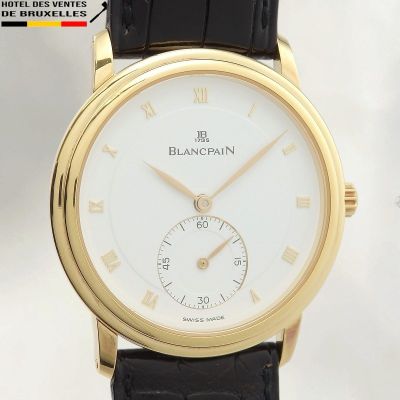 gros plan d'une montre-bracelet en or avec des chiffres romains