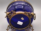 an image of a blue vase with a gold rim and a chain around it
