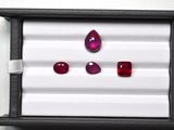 three ruby gems are displayed in a display case on a white surface
