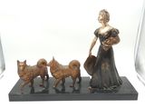 une statue représentant une femme tenant un panier et trois chiens