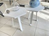 two tables with vases on them in a living room