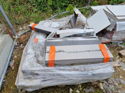 une pile de cartons et un ordinateur portable posé par terre