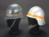 pair of helmets on mannequin heads against a gray background