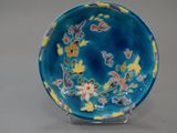 a blue and yellow bowl with flowers on it