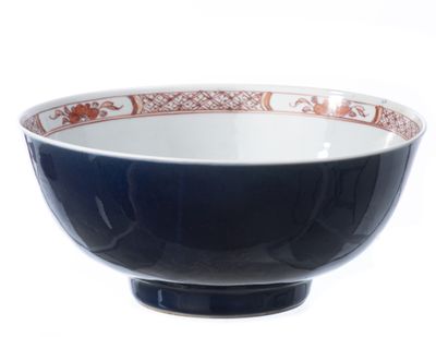 un bol noir orné d'un motif rouge et blanc