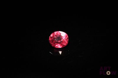 un gros plan sur un diamant rouge dans l'obscurité