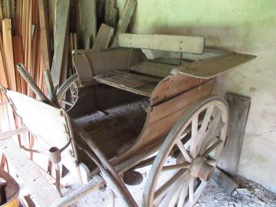 an old wooden cart with a wooden seat in a room