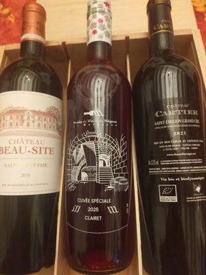 trois bouteilles de vin dans un coffret en bois sur une table