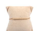 a white pillow with a gold chain on top of it