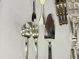 a lot of silverware on a white plate on a table