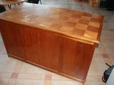 a wooden table with a checkered top in the middle of a room