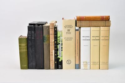 plusieurs livres sont empilés sur une surface blanche