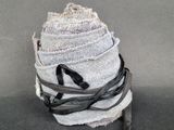 une pile de jeans enveloppés dans un ruban noir et blanc