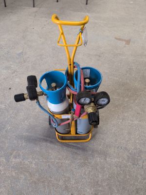 un petit chariot jaune avec deux seaux bleus et une poignée jaune