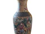 un vase orné d'une peinture posé sur une surface blanche
