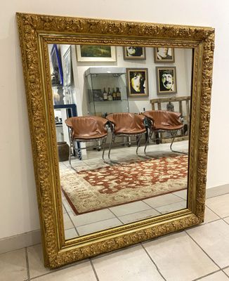 Grand miroir en bois et stuc doré à décor de fleurs et feuil…