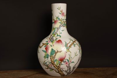 un vase blanc avec des fleurs et des oiseaux peints dessus