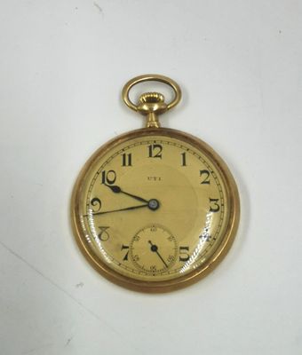 une montre de poche en or sur une surface blanche