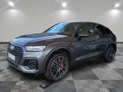 une Audi QX 2021 grise garée dans une grande pièce