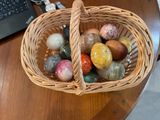 a wicker basket filled with eggs on a wooden table