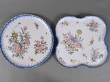 deux assiettes ornées de fleurs et de papillons, posées sur une table