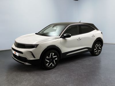 Le SUV blanc est garé dans une pièce au sol noir.
