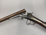 an old gun with a wooden handle on a white surface