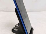 a close up of a cell phone on a stand on a white surface