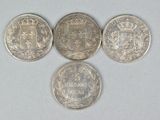 four silver coins are arranged in a circle on a white surface