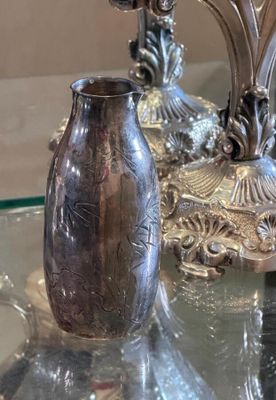 two silver vases sitting on a glass table