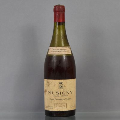 an old bottle of wine sitting on top of a glass table