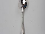 a silver spoon with a spoon handle on a white surface