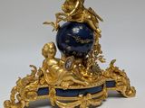 a gold and blue clock sitting on top of a table