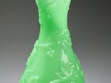green glass vase with a gold rim sitting on a white surface