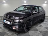 La Citroën noire est garée dans le garage, sur un sol à damier.