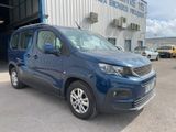 La camionnette bleue est garée devant un immeuble.