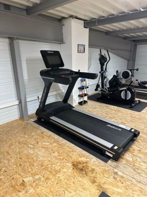 une salle de sport équipée de tapis de course et d'autres appareils