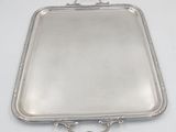 an antique silver tray with handles on a white table