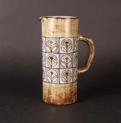 a brown and blue vase with a handle on a table