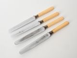 three knives with wooden handles on a white surface