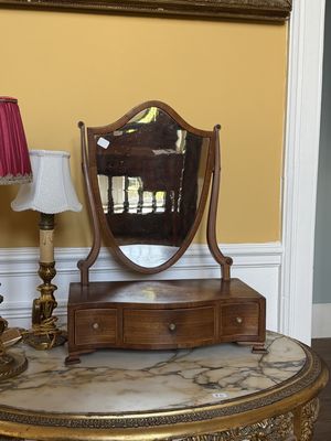 une table sur laquelle se trouvent un miroir et une lampe