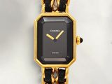 a black and gold watch with a chain around it