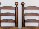 two wooden chairs that are sitting next to each other