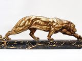 a gold statue of a tiger on a marble base