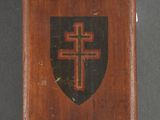 an old wooden plaque with a cross and shield on it