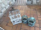 deux cages à oiseaux posées par terre l'une à côté de l'autre