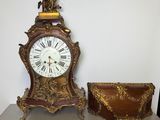 a clock that is sitting on a table next to a purse
