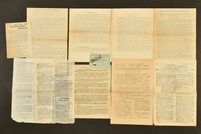 plusieurs pages de vieux papiers posées sur une table, sur fond noir