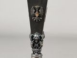 a silver vase with a skull and crossbone decoration on it