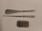 a spoon, knife, and card case sitting on a table
